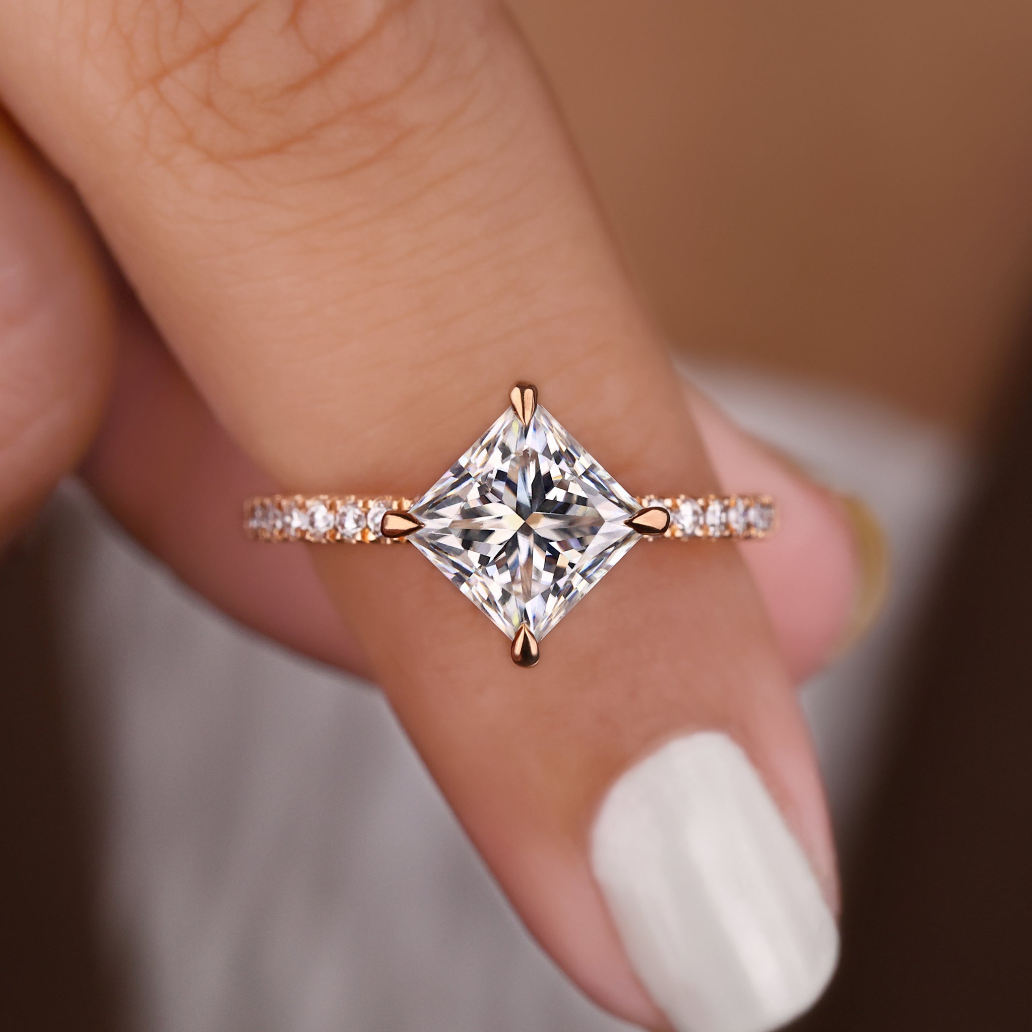 A princess cut moissanite ring shown in a close-up view.