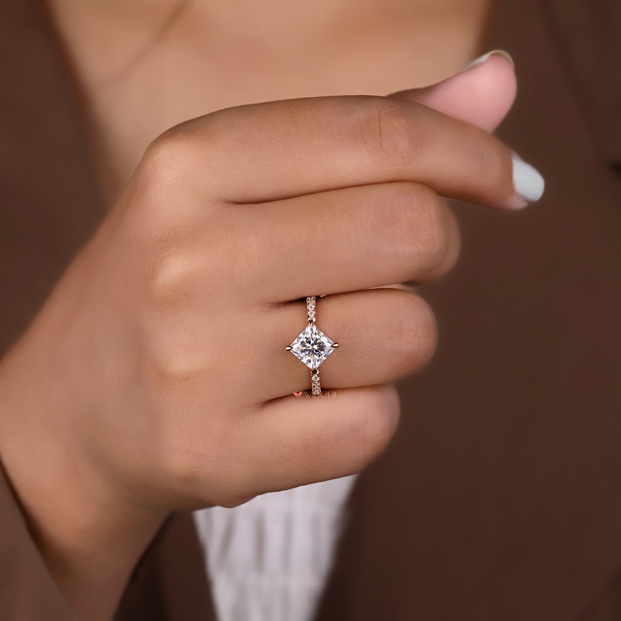 A ring featuring round cut side stones next to the center gem.