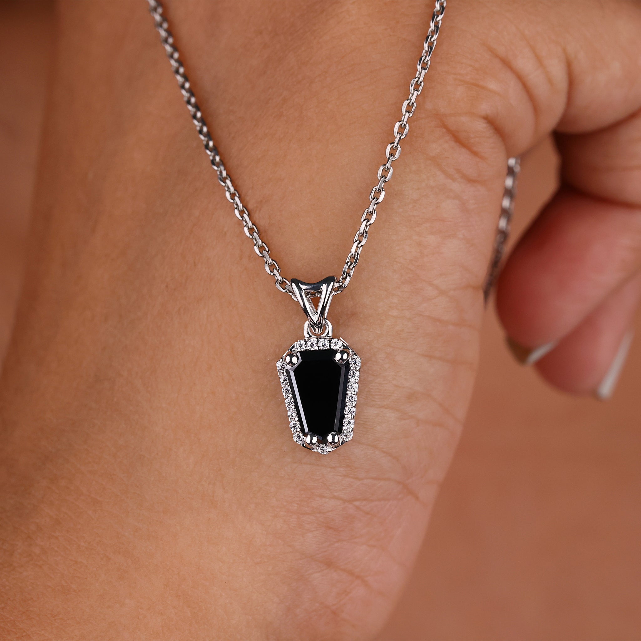 Halo pendant set in a coffin pendant for added brilliance.