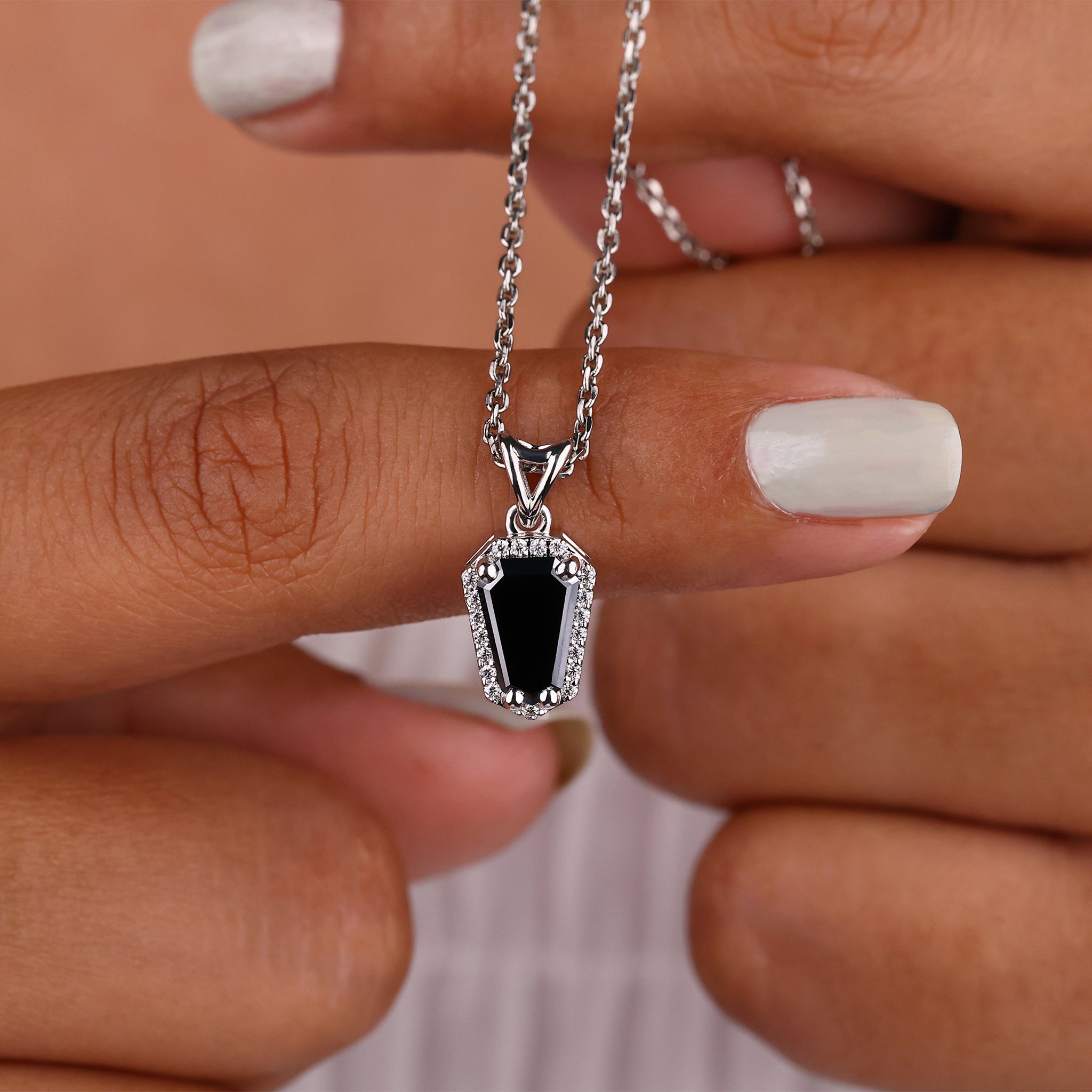 Coffin pendant with halo style and round cut diamonds for sparkle.