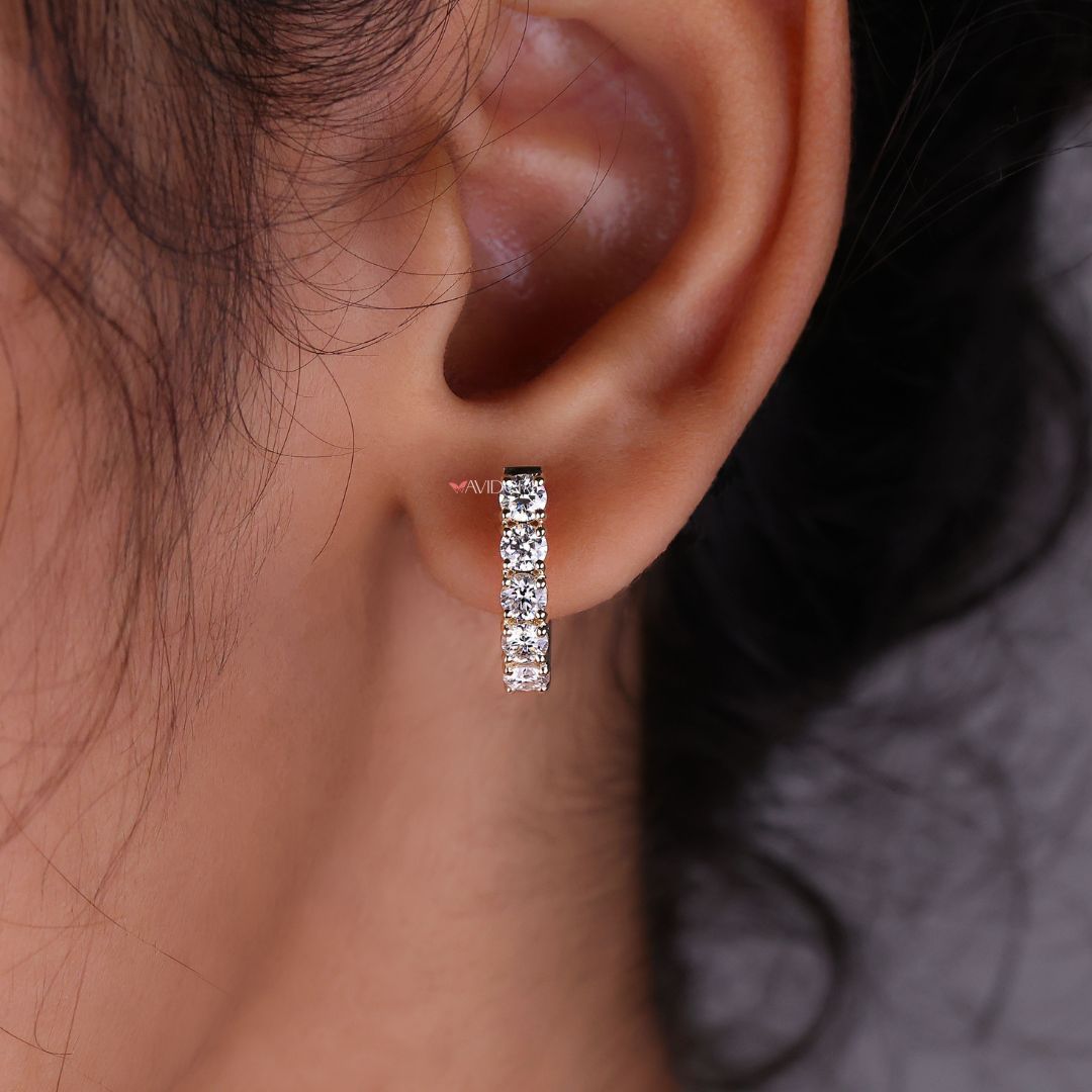 Gold hoop earrings featuring round cut diamonds