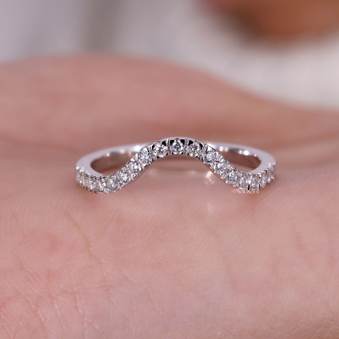 A round cut moissanite band shines with brilliant clarity.
