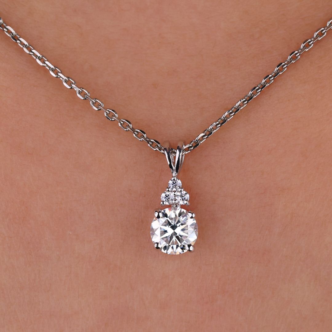 Round cut moissanite pendant set in white gold.
