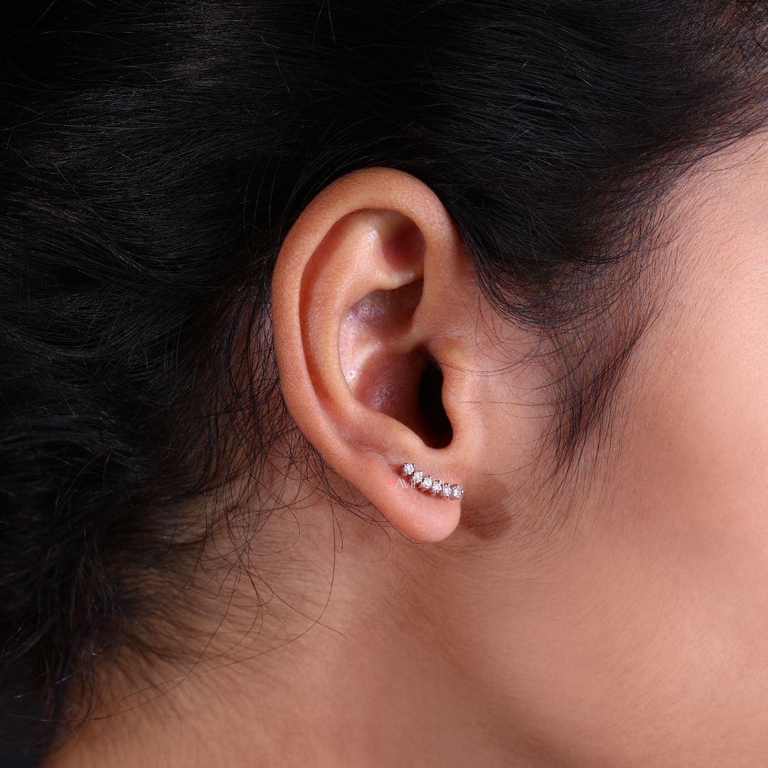 Lab grown diamond crawler earrings presented on a smooth white surface.