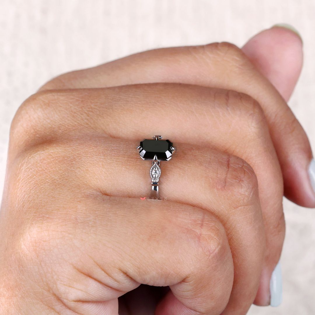 Milgrain ring with a cathedral setting and an elegant emerald cut diamond.