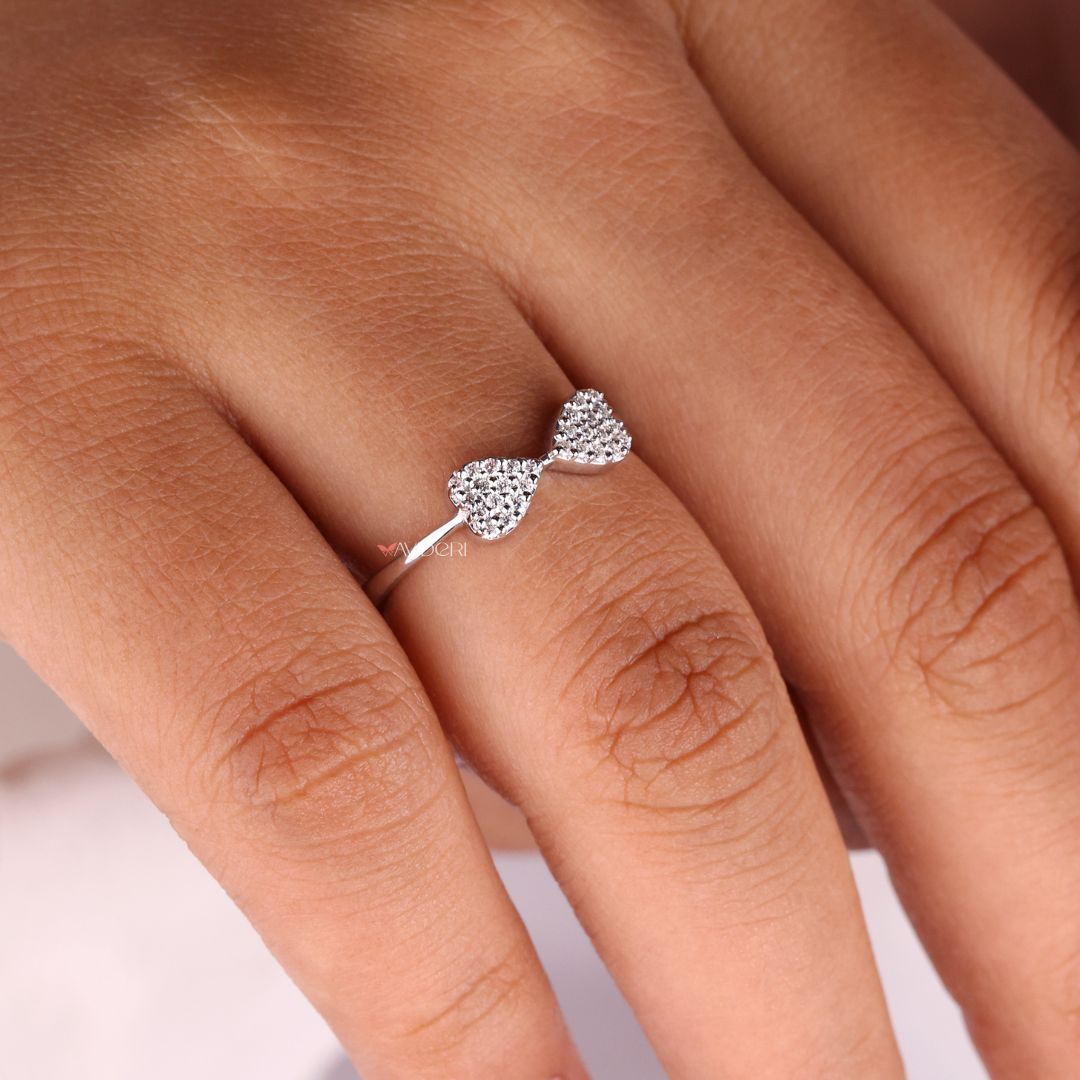 Bow design ring featuring a round brilliant centerpiece