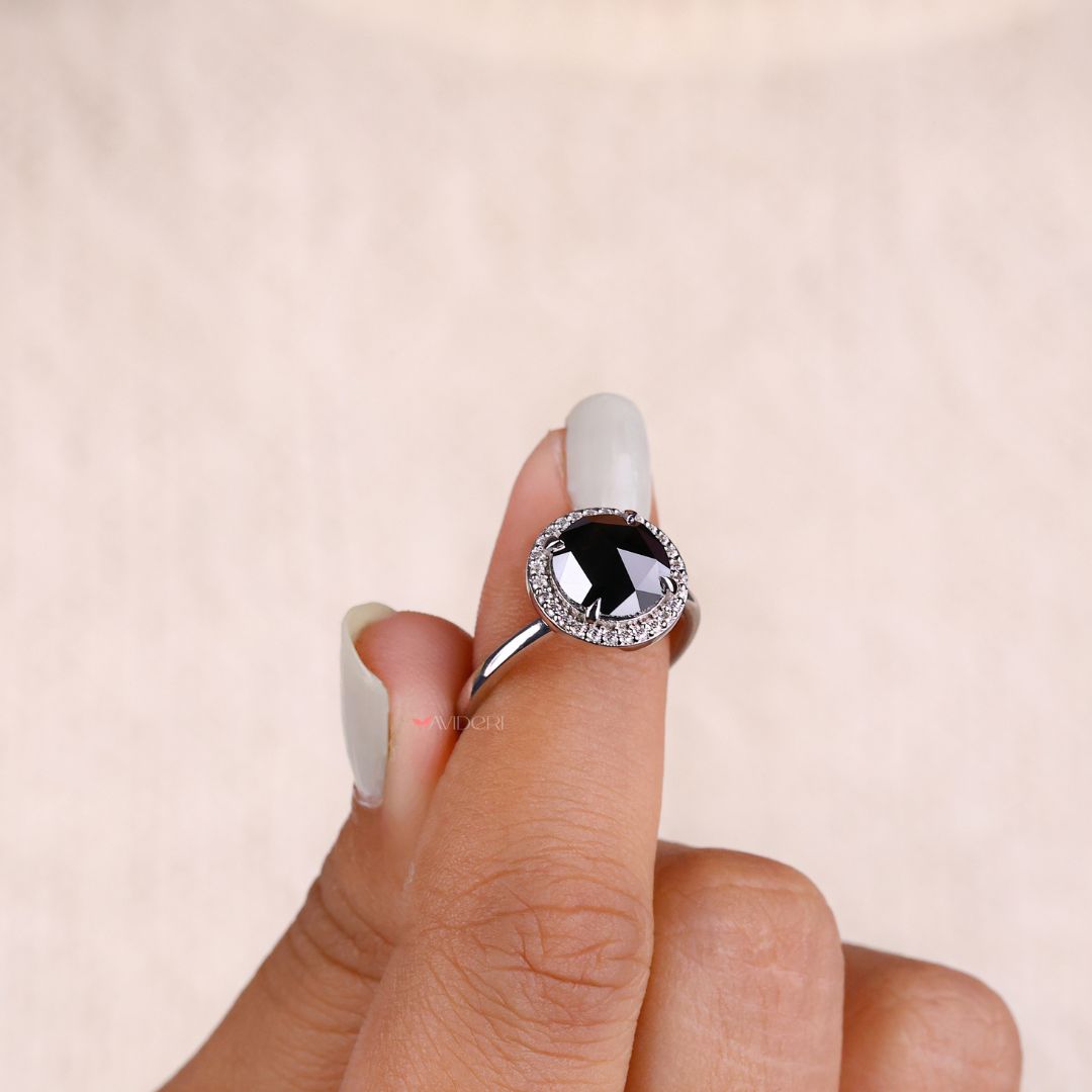 Halo engagement ring with a sparkling round rose cut moissanite center.
