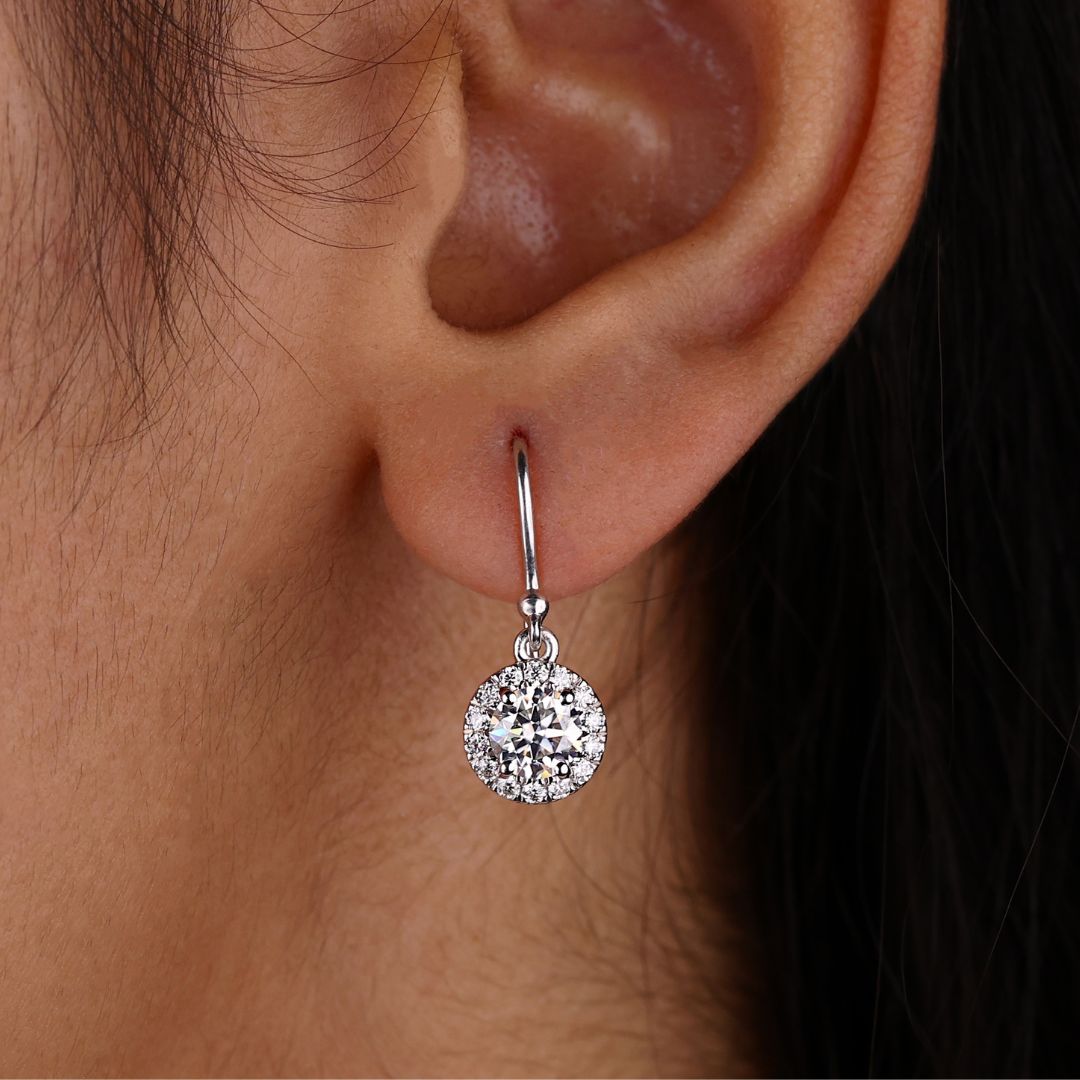 Round Cut Moissanite halo earrings in white gold with prong settings.