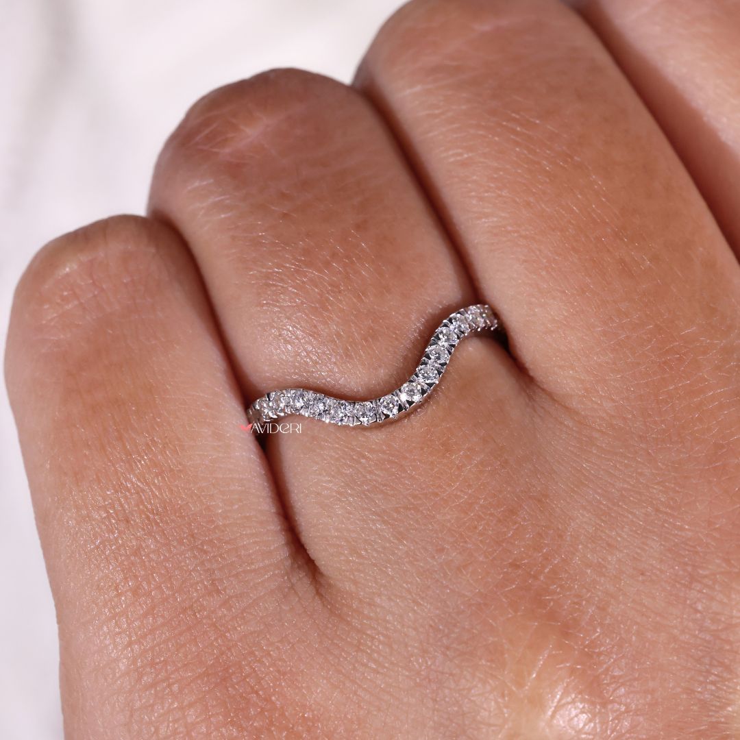 A white gold wedding band has a cool, polished finish.