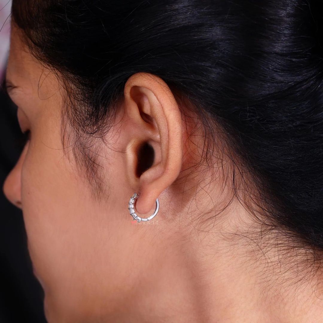 A single hoop earring featuring baguette cut diamonds