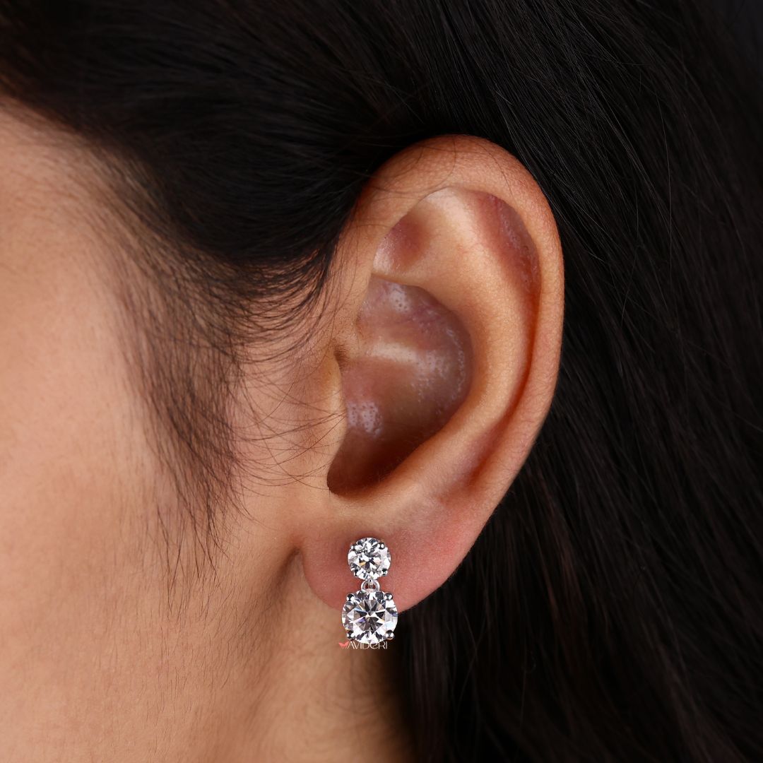Drop earrings featuring round cut Moissanite in white gold settings.