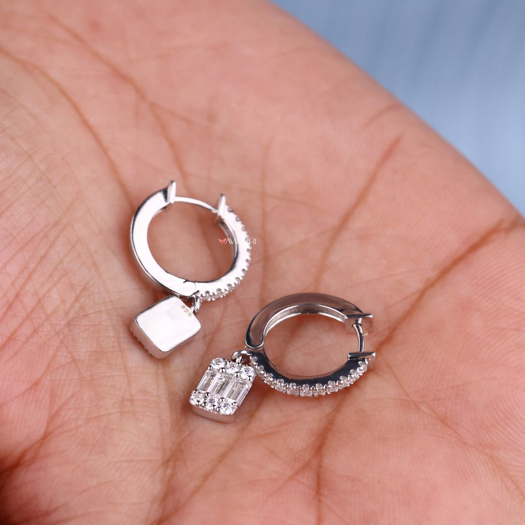 White gold earrings featuring baguette cut and round Moissanite stones.