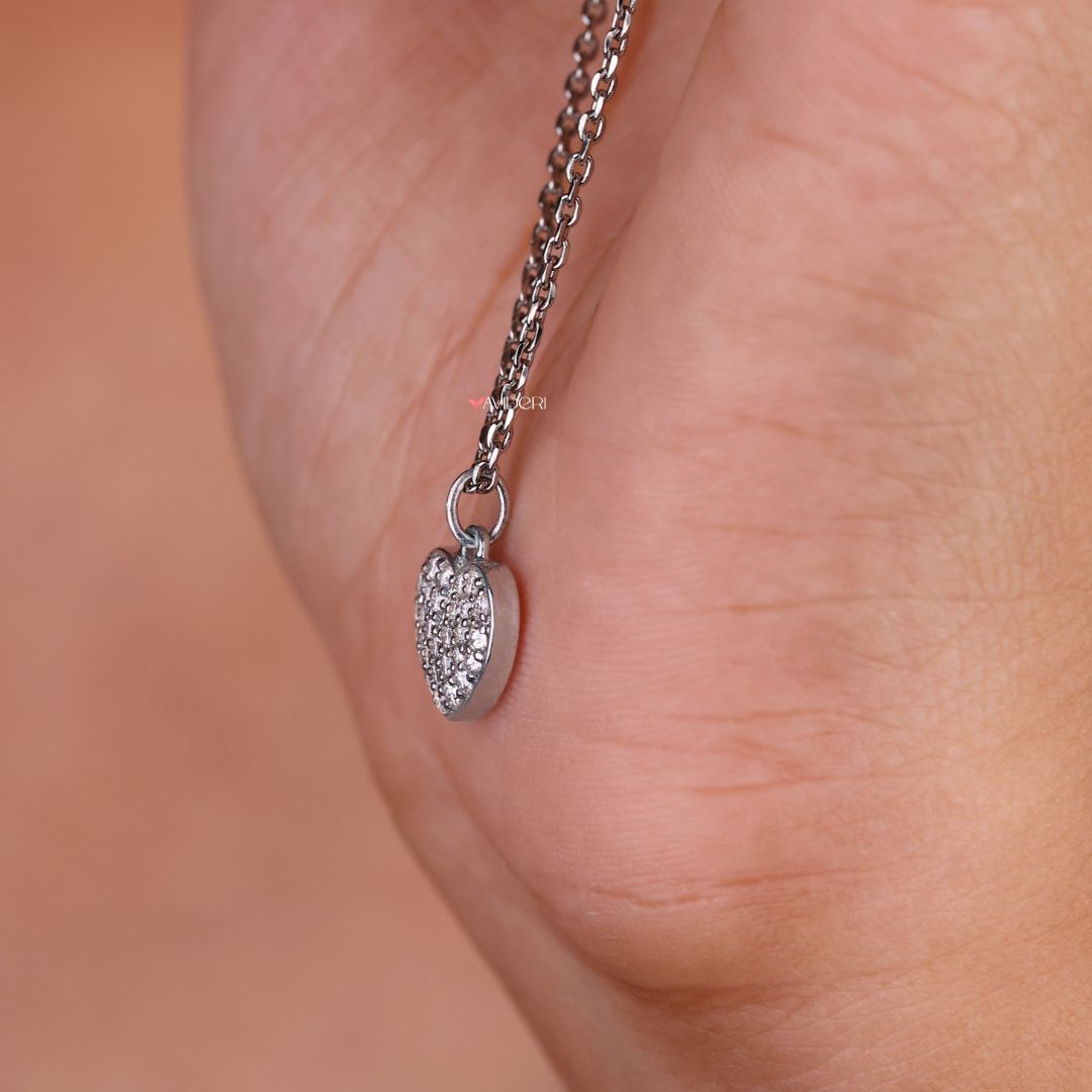 Cluster pendant with a heart shape featuring a round moissanite cut stone.