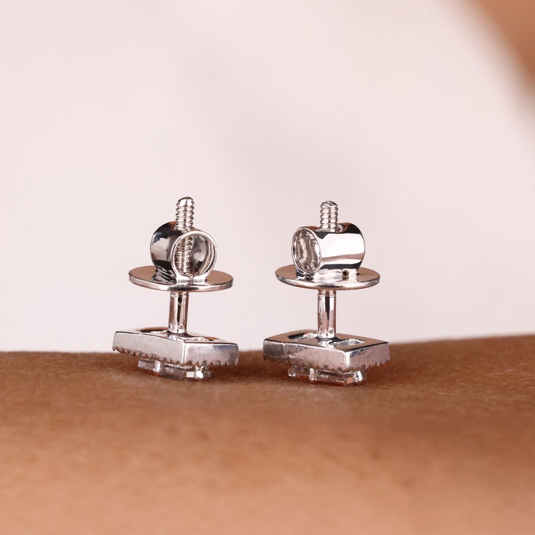 White gold earrings with prong settings featuring baguette and round cuts.