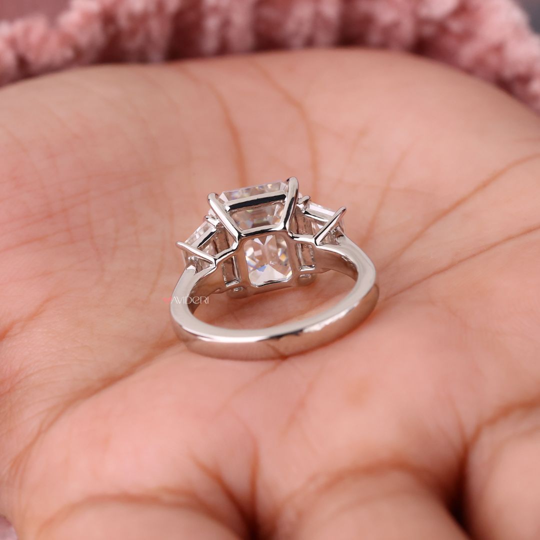 White gold engagement ring with a sparkling emerald cut center stone.