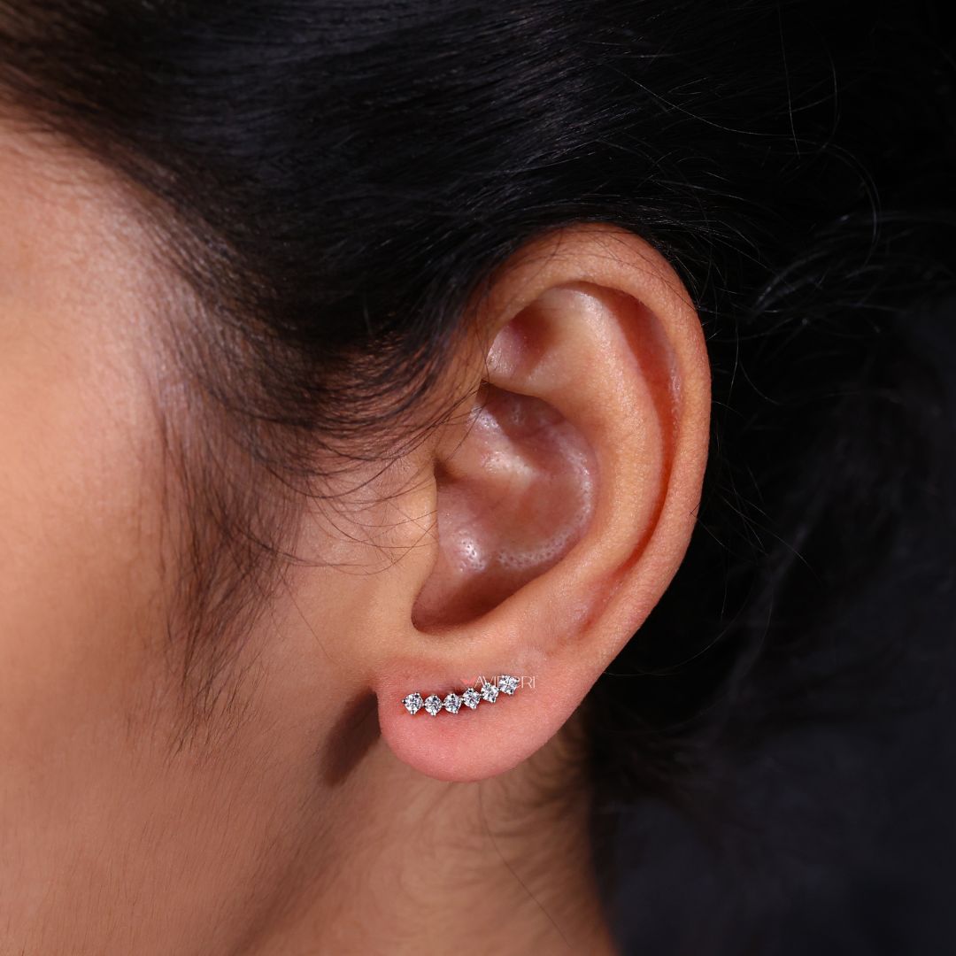 A pair of cartilage stud earrings displayed on a jewelry stand.