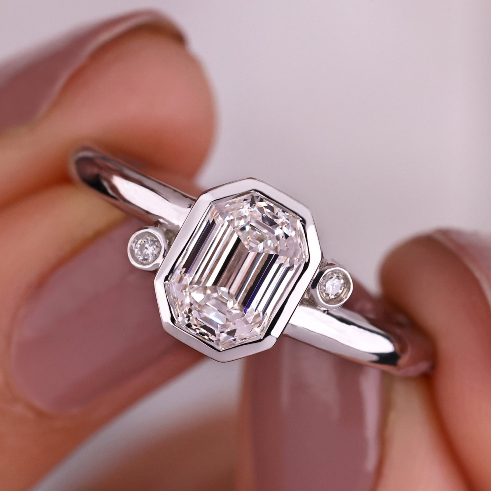 A stunning emerald and diamond engagement ring with intricate detailing.