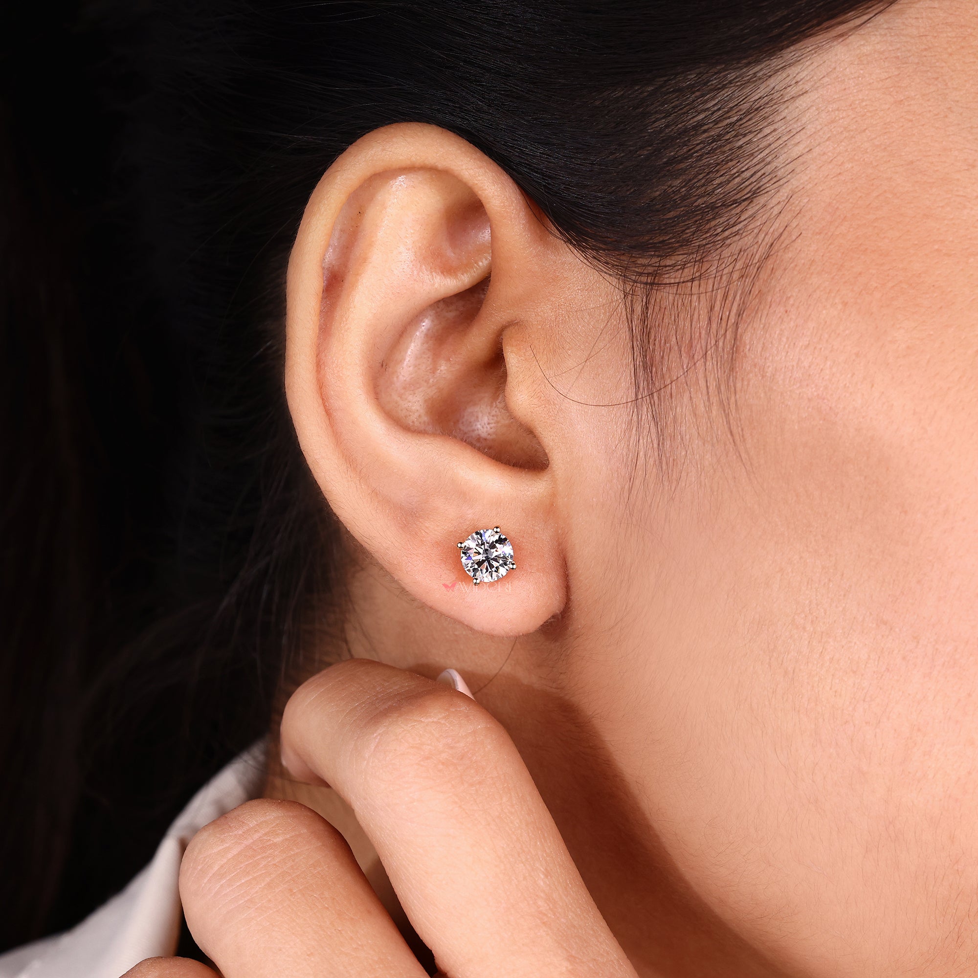 Diamond stud earrings in yellow gold setting.
