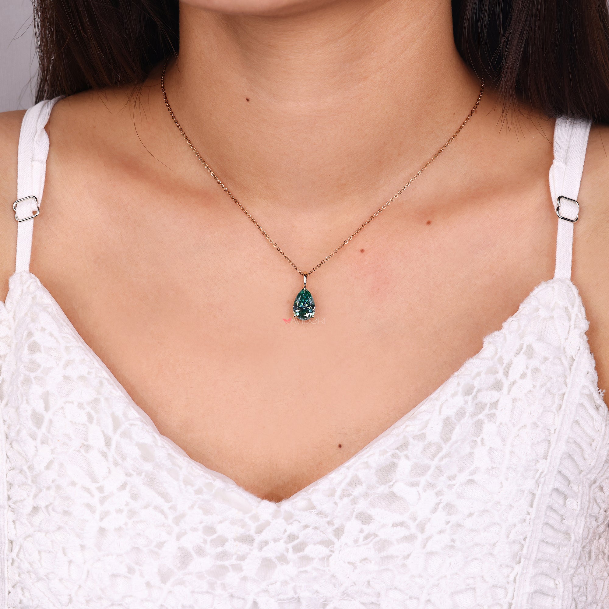 Handmade pendant featuring a cyan blue moissanite.