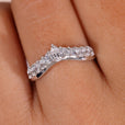 Curved diamond wedding band with a unique shape.