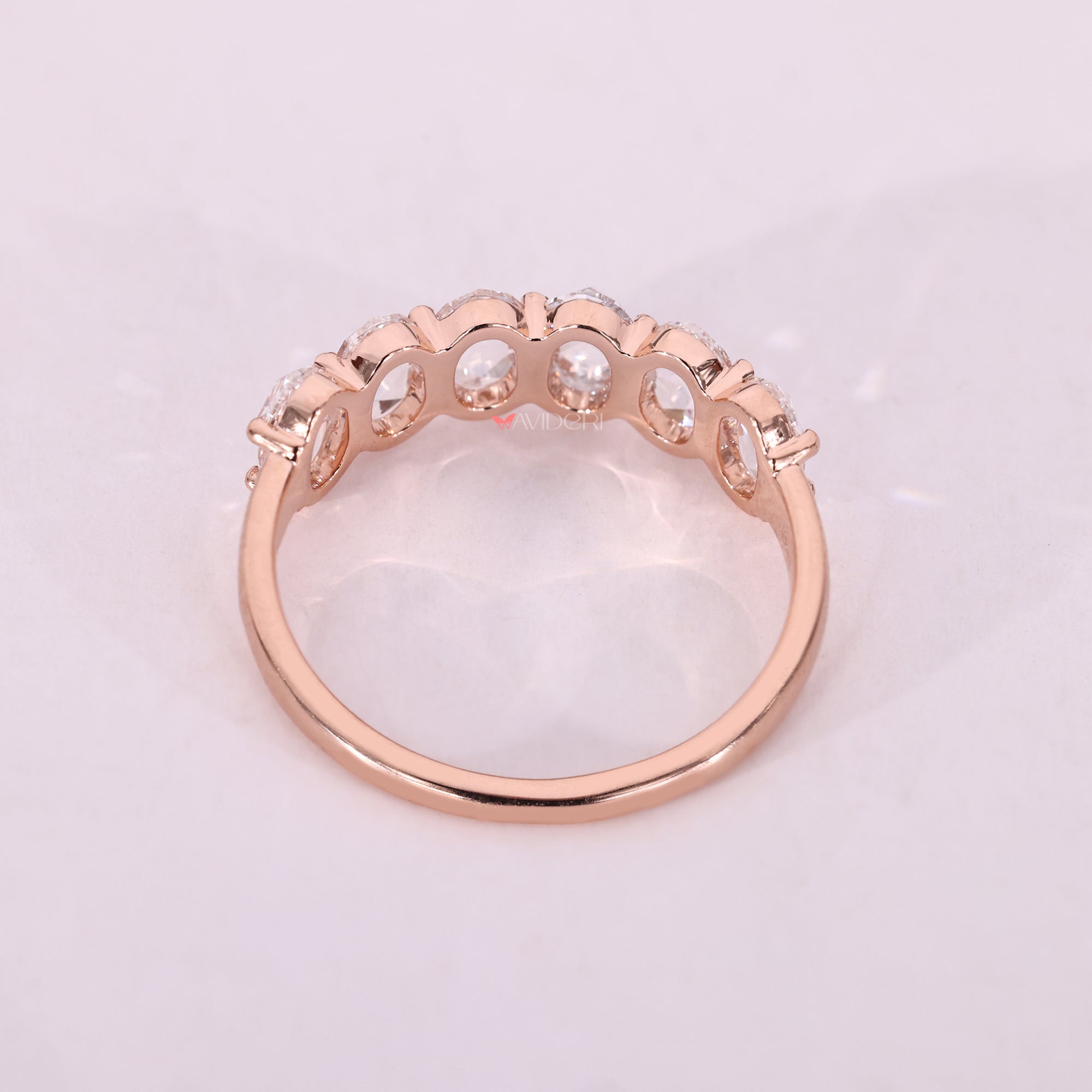 Rose gold oval wedding band featuring lab diamonds.