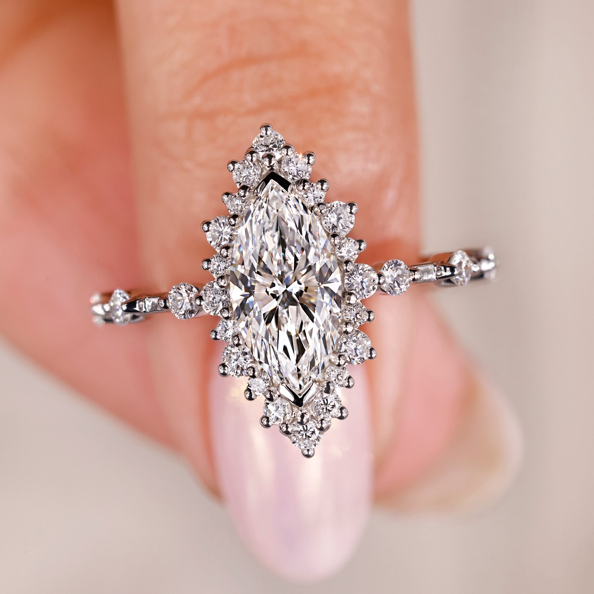 marquise diamond engagement ring with round diamond accents in white gold.