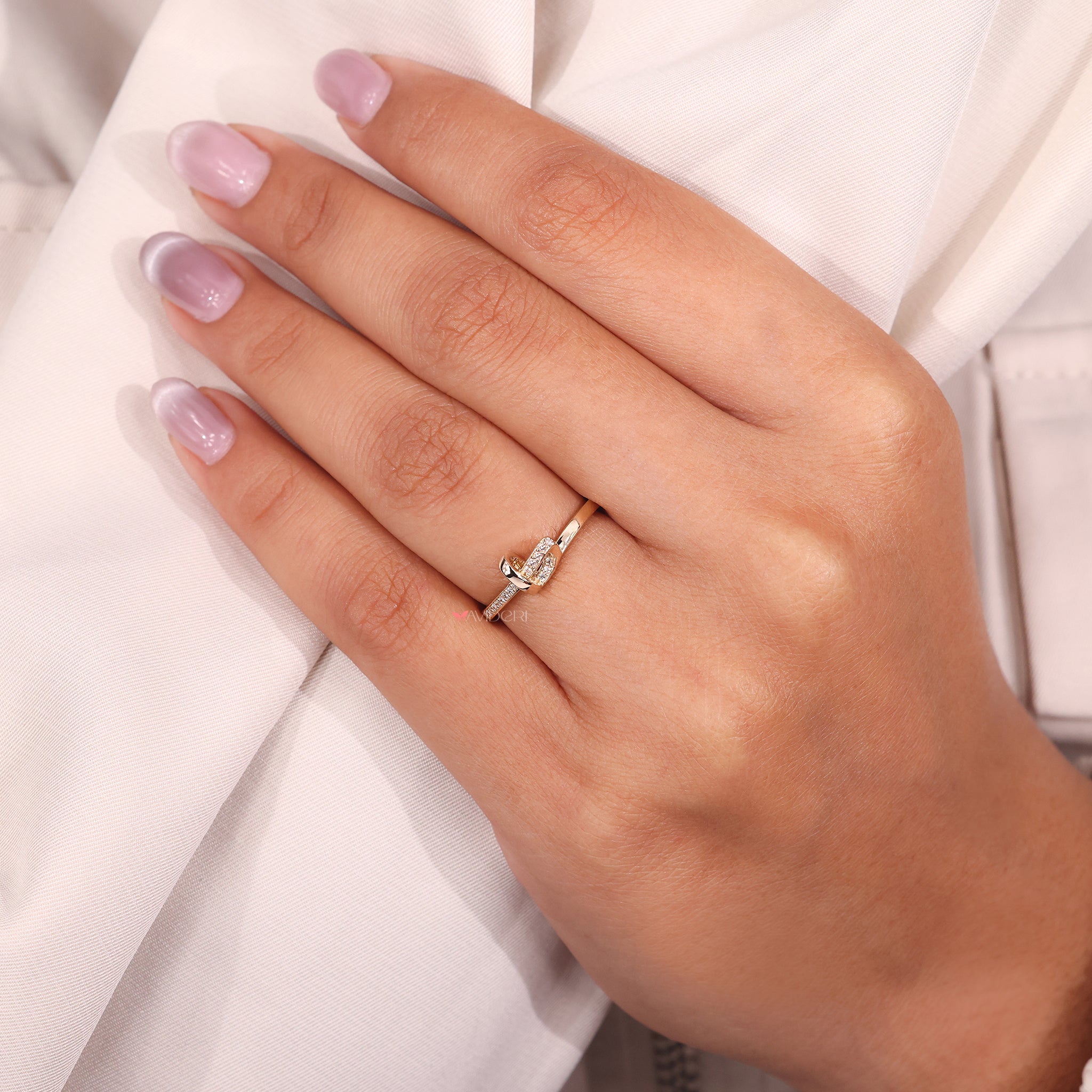 Pavé diamond knot band features fine details and prong set stones.