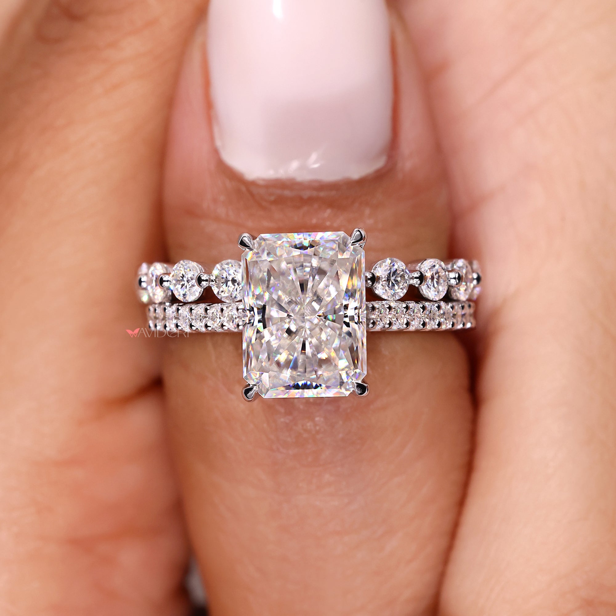 Engagement ring with radiant moissanite and shared prong band.