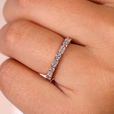 Emerald and round eternity band featuring sparkling diamonds.