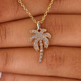 Gold palm tree pendant featuring intricate details.
