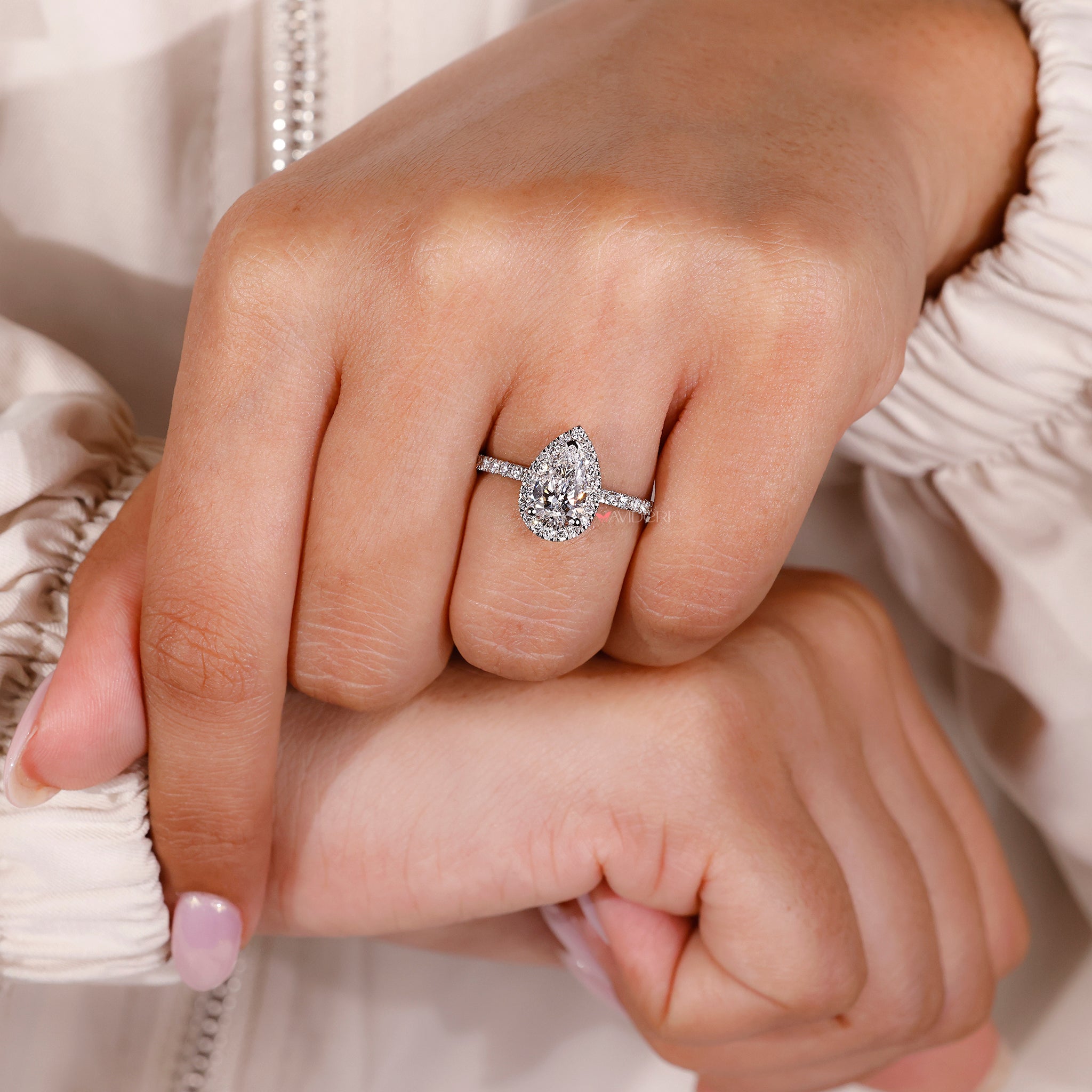 V prong setting holding a pear cut lab diamond.
