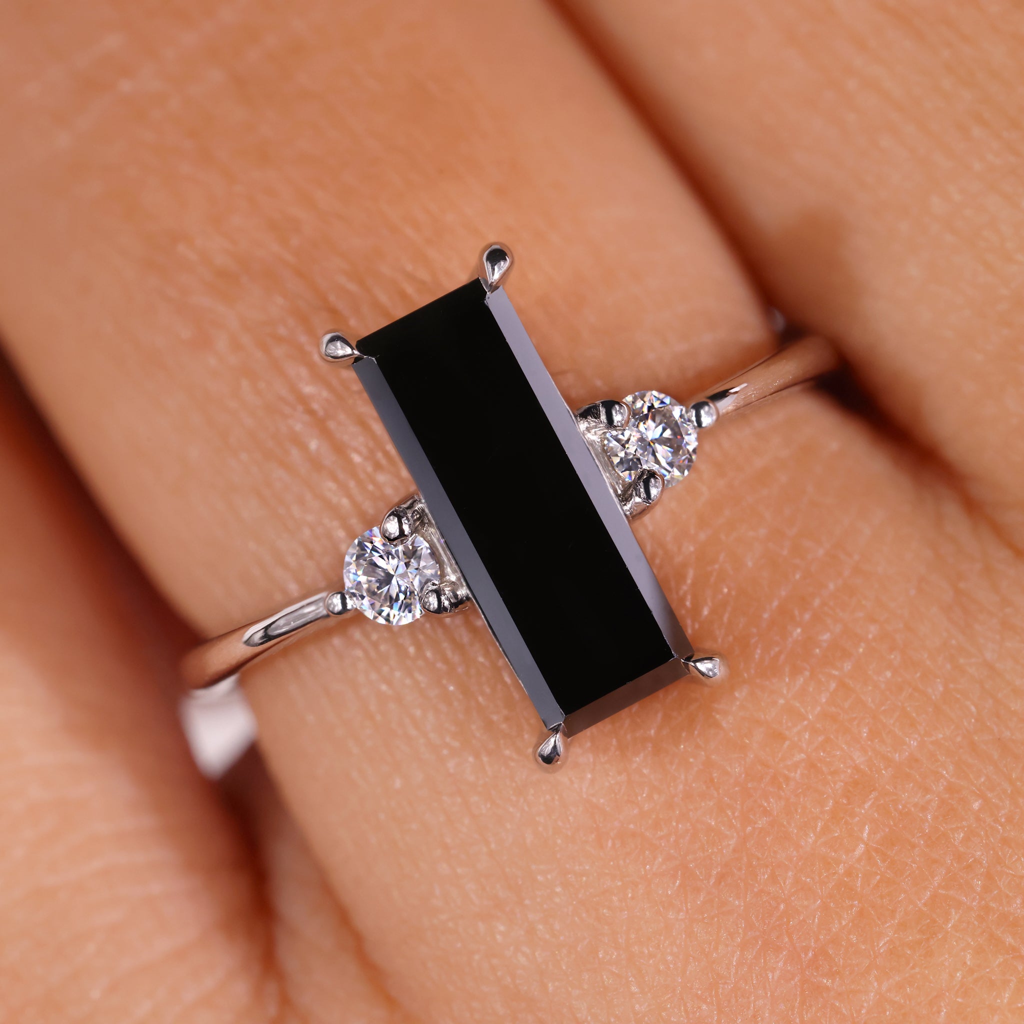3 stone ring featuring a baguette cut center stone