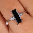 3 stone ring featuring a baguette cut center stone