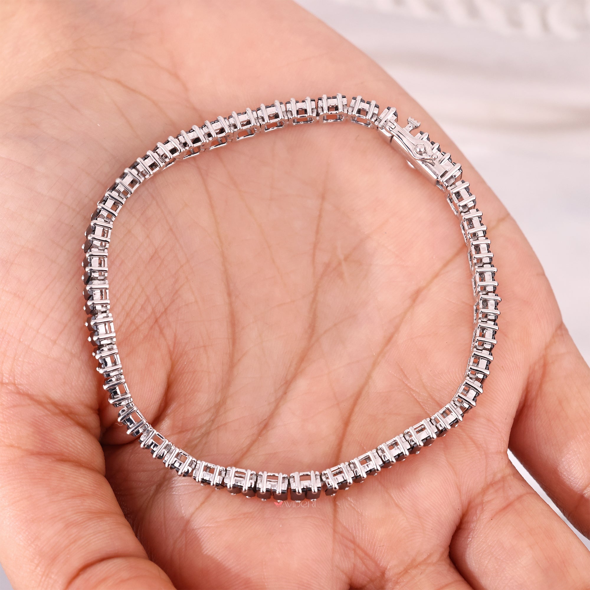 White gold tennis bracelet with black stones.