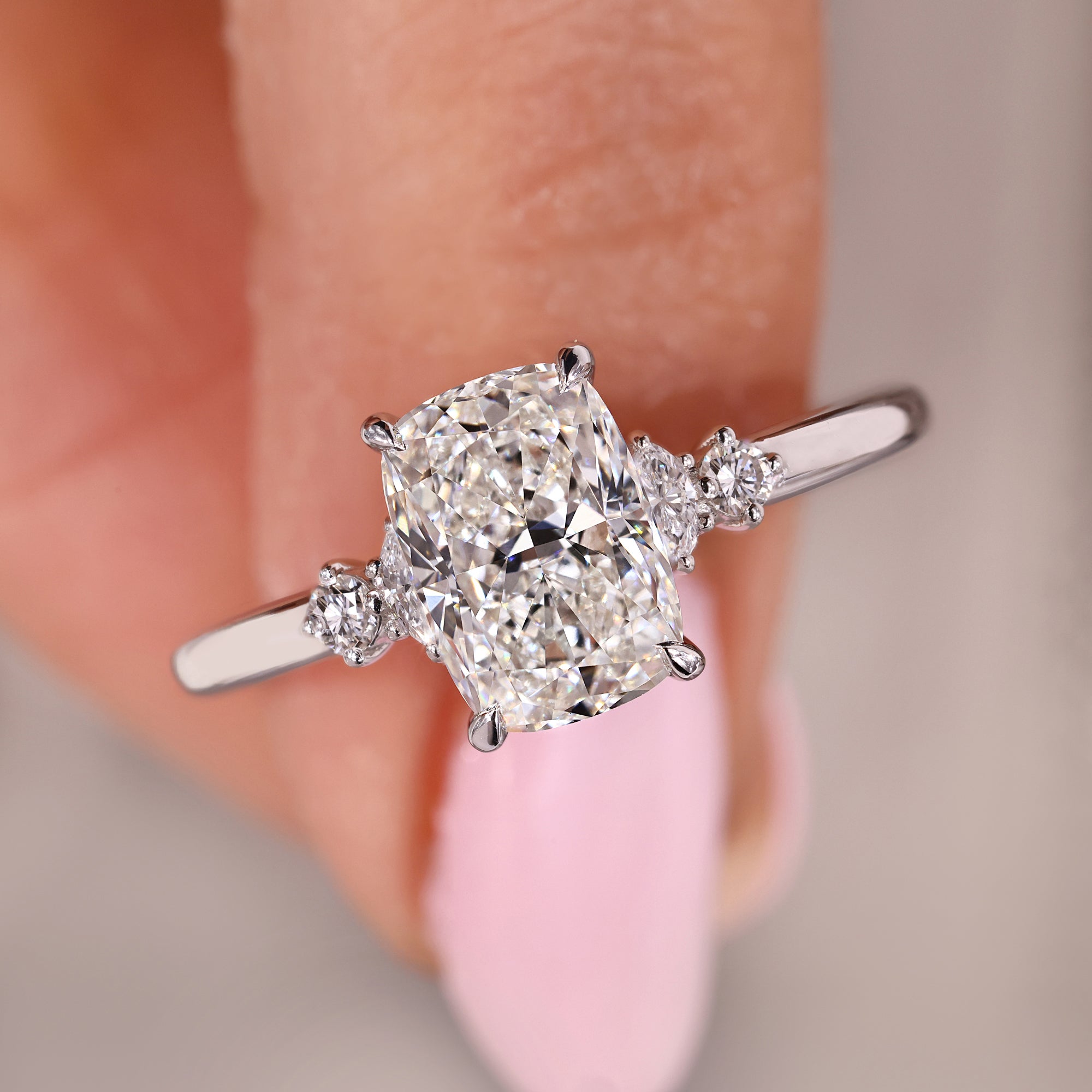 Cushion cut diamond ring set in round cut side stone design.