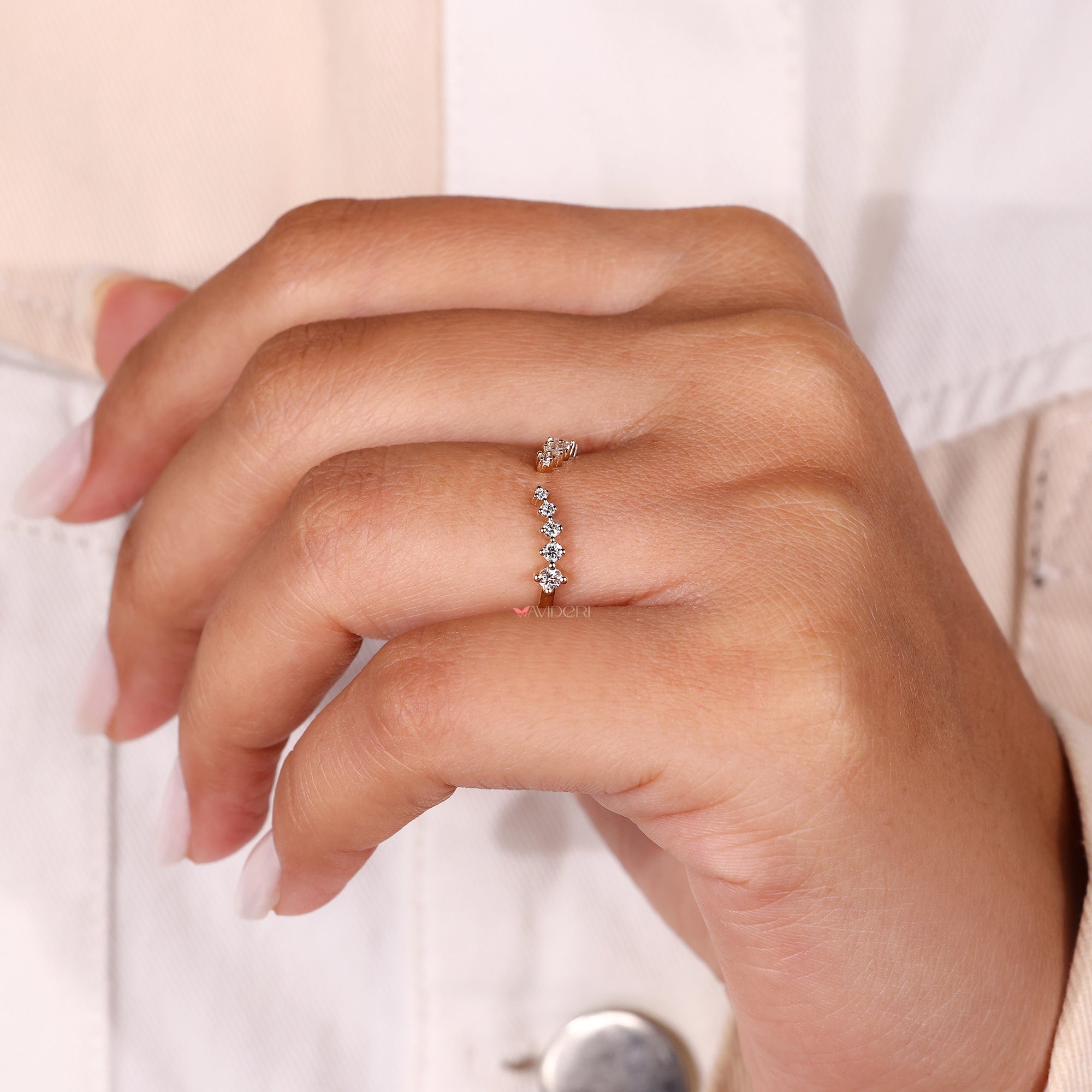 Shared prong half eternity ring with round cut diamonds.