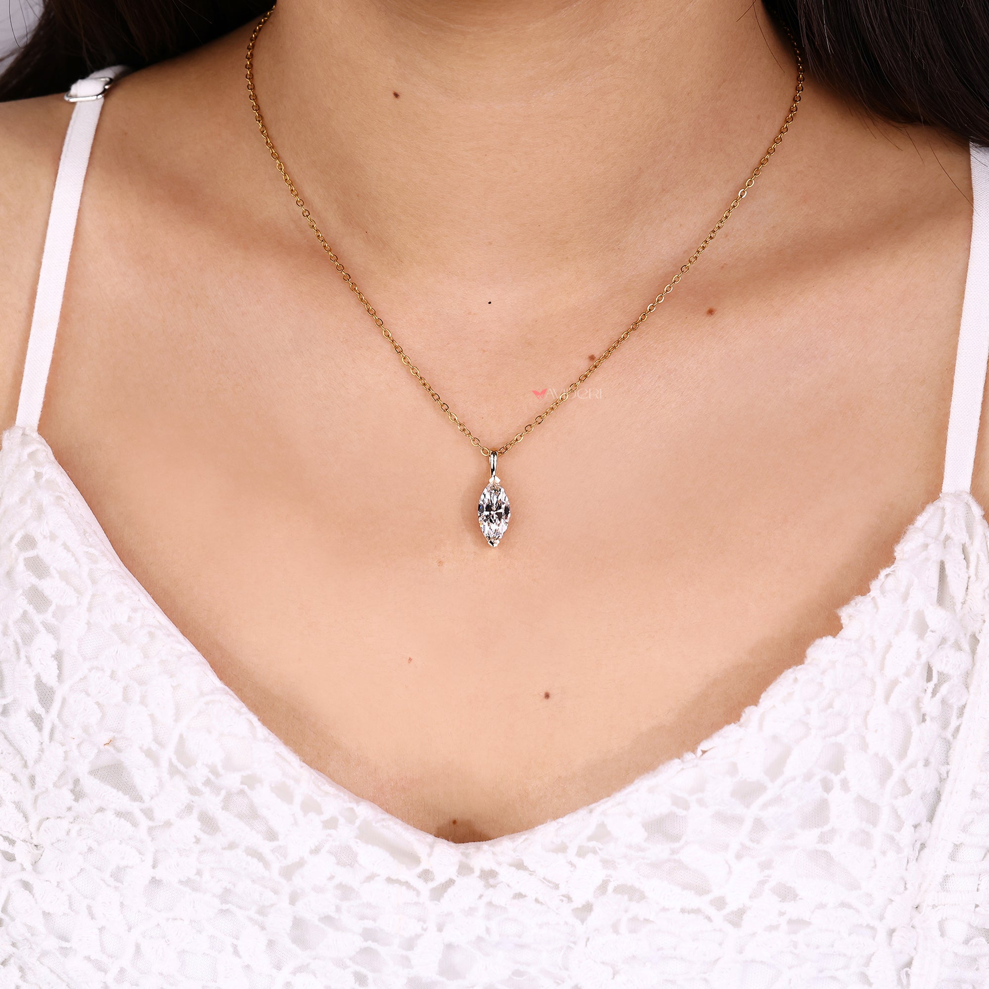 Necklace with a pendant worn by a person in a white lace top