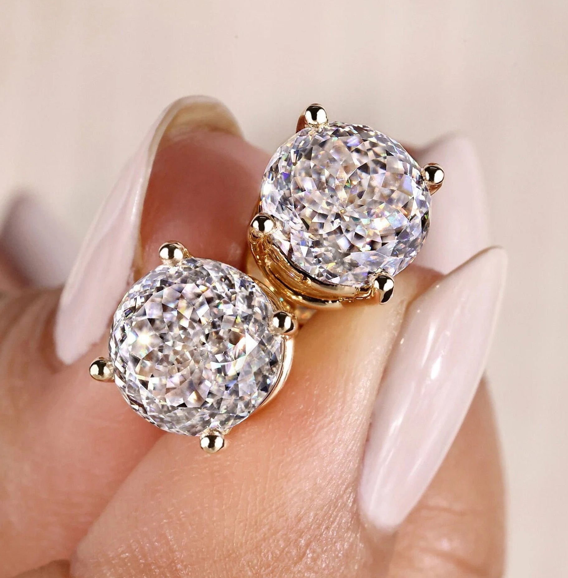 Portuguese Cut earrings with 4 prong earring settings in yellow gold.