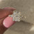 Radiant diamond cut ring with a brilliant round cut diamond ring setting.