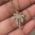 Gold palm tree pendant featuring intricate details.