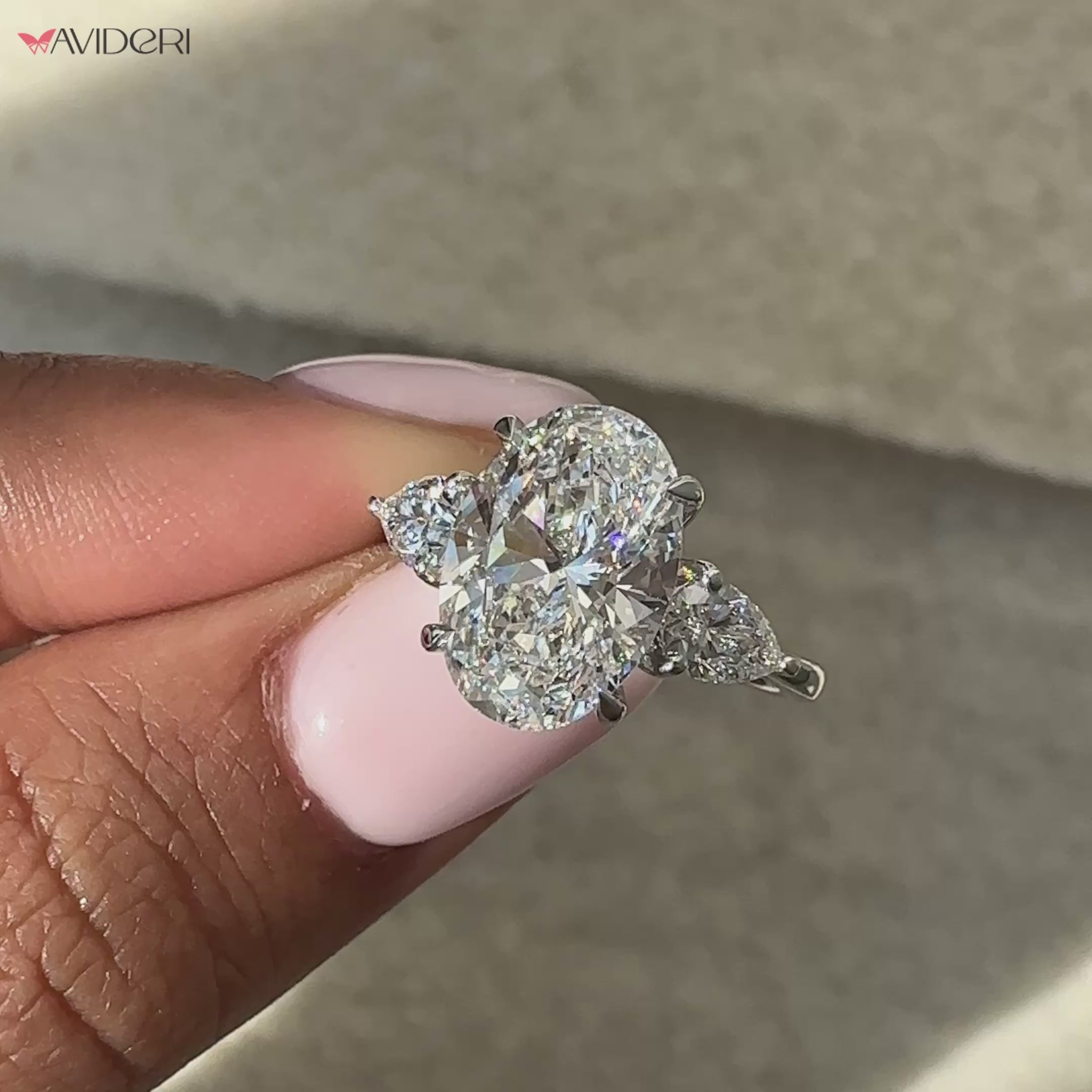 Pear diamond ring with a three stone oval engagement ring setting for a bold look.