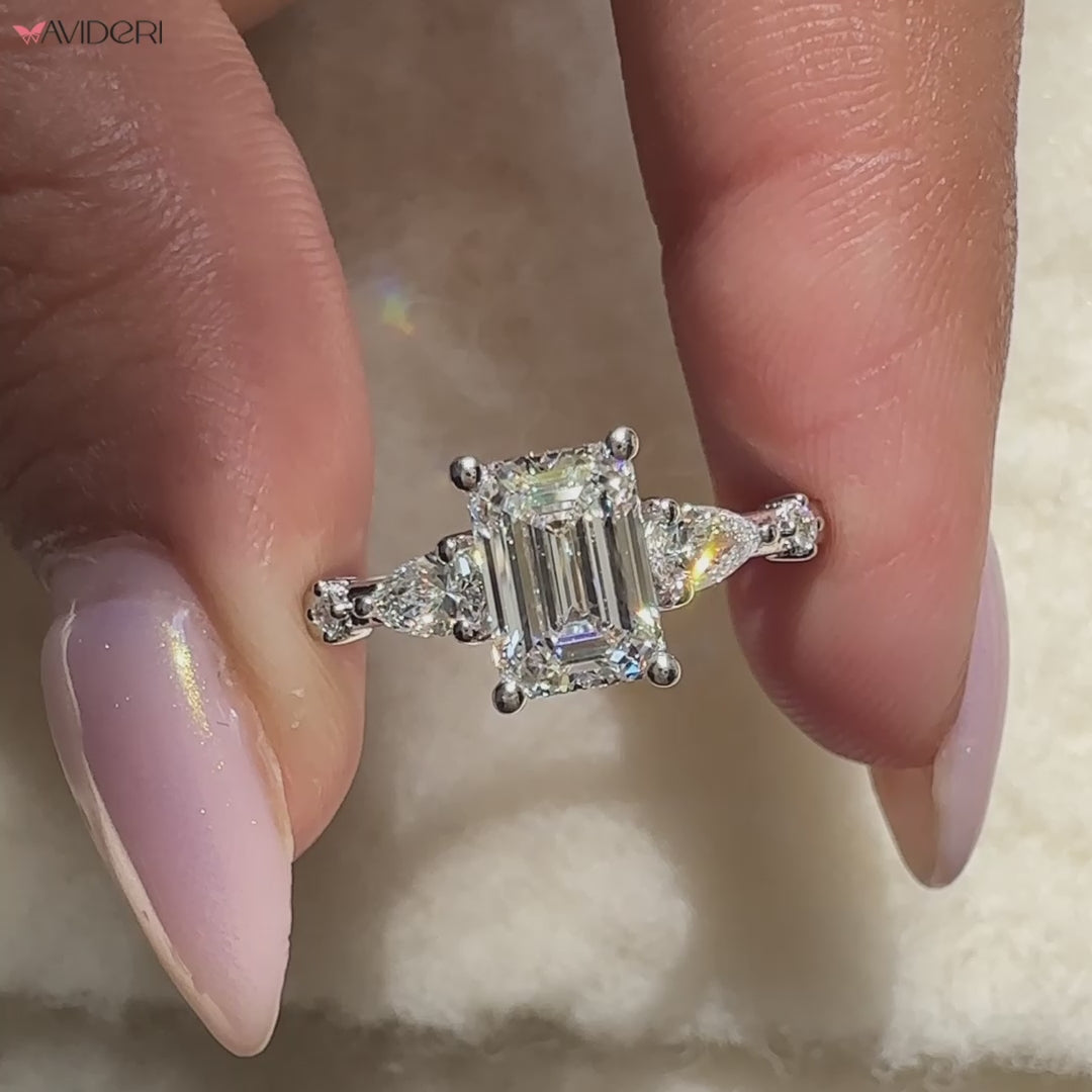 Buy engagement ring designed with emerald diamond and 2 pear side diamond ring.