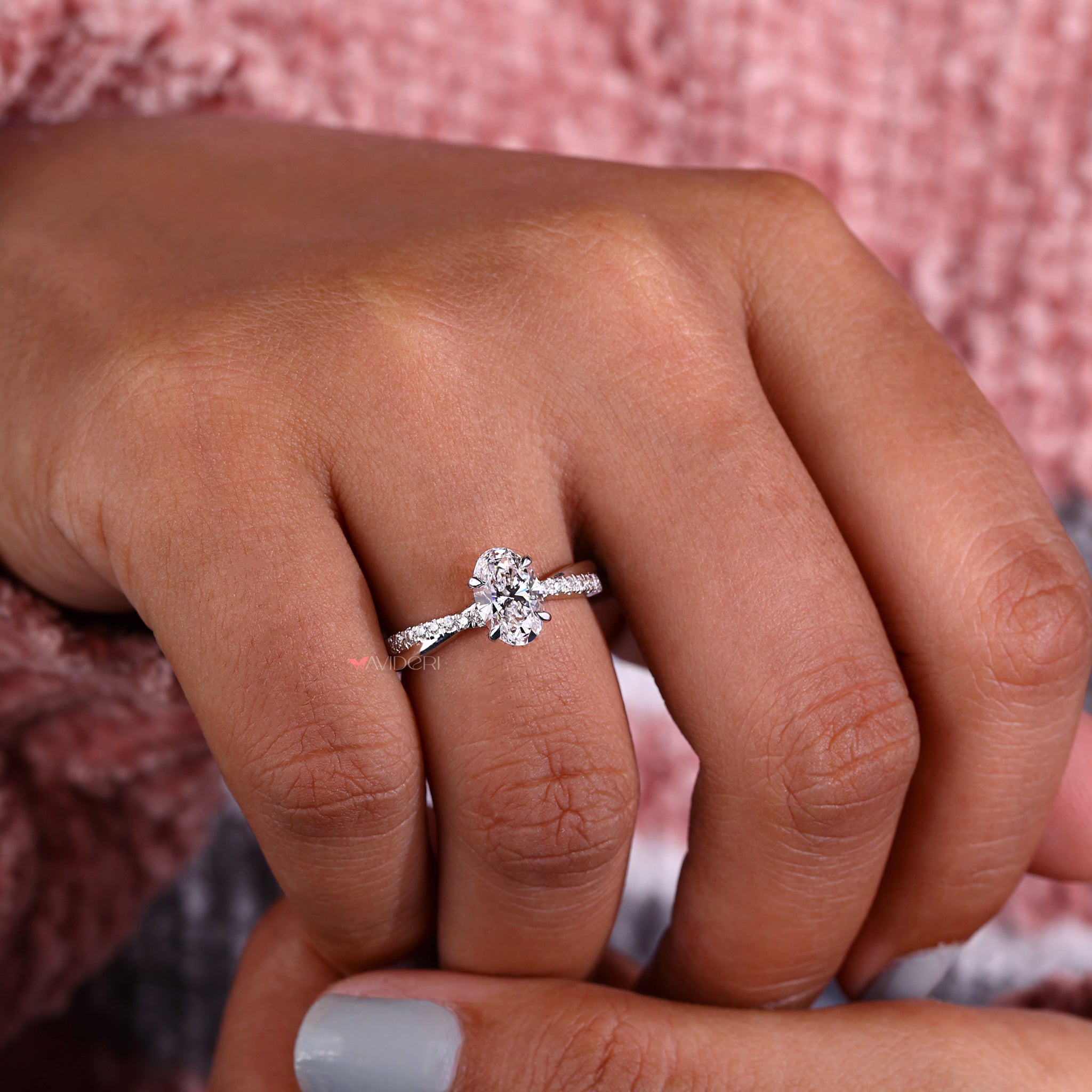 Twisted ring design with an oval cut diamond and pave diamond ring accents for added sparkle and sophistication.