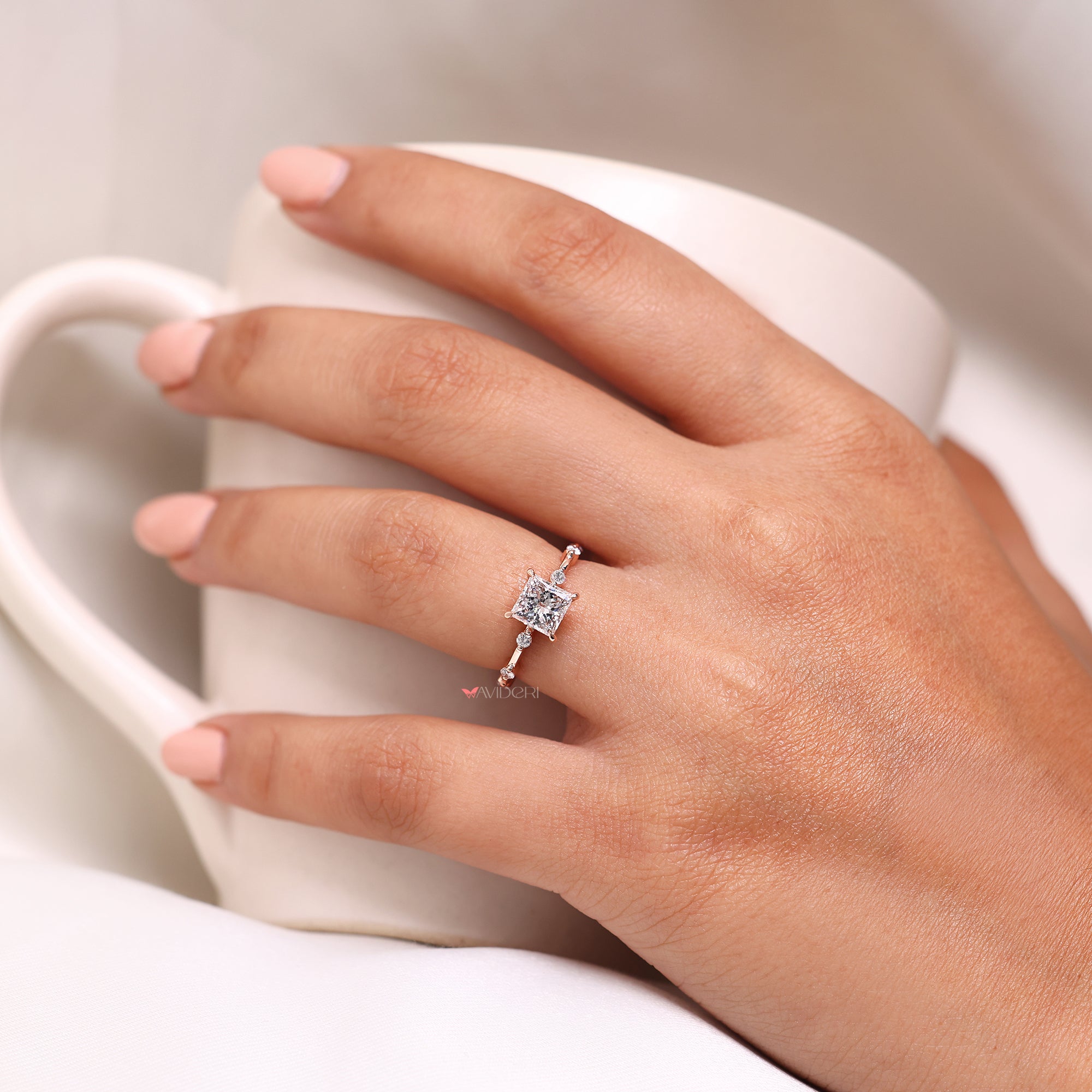 Round cut side stone in rose gold engagement ring.