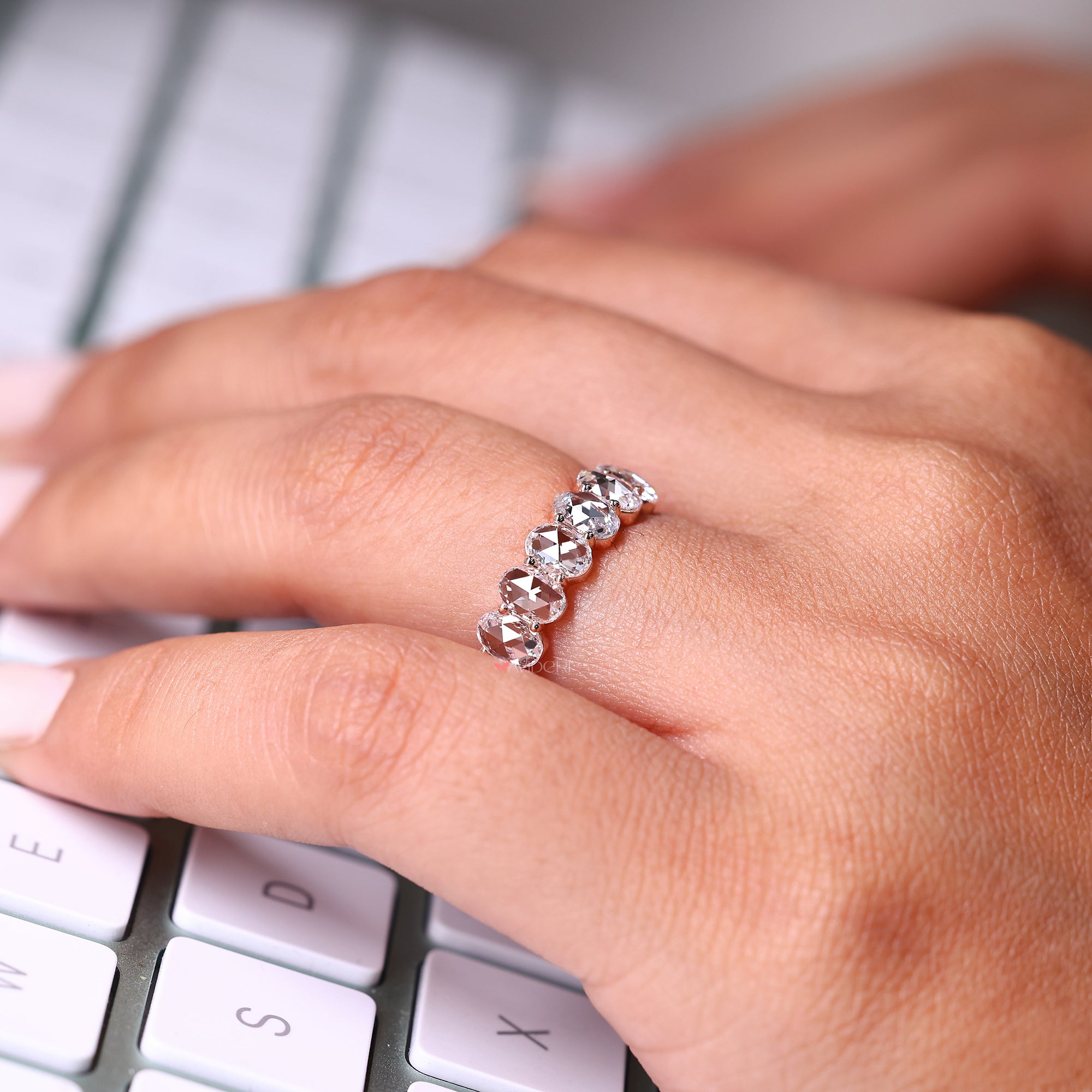 Rose gold six stone oval cut wedding band.