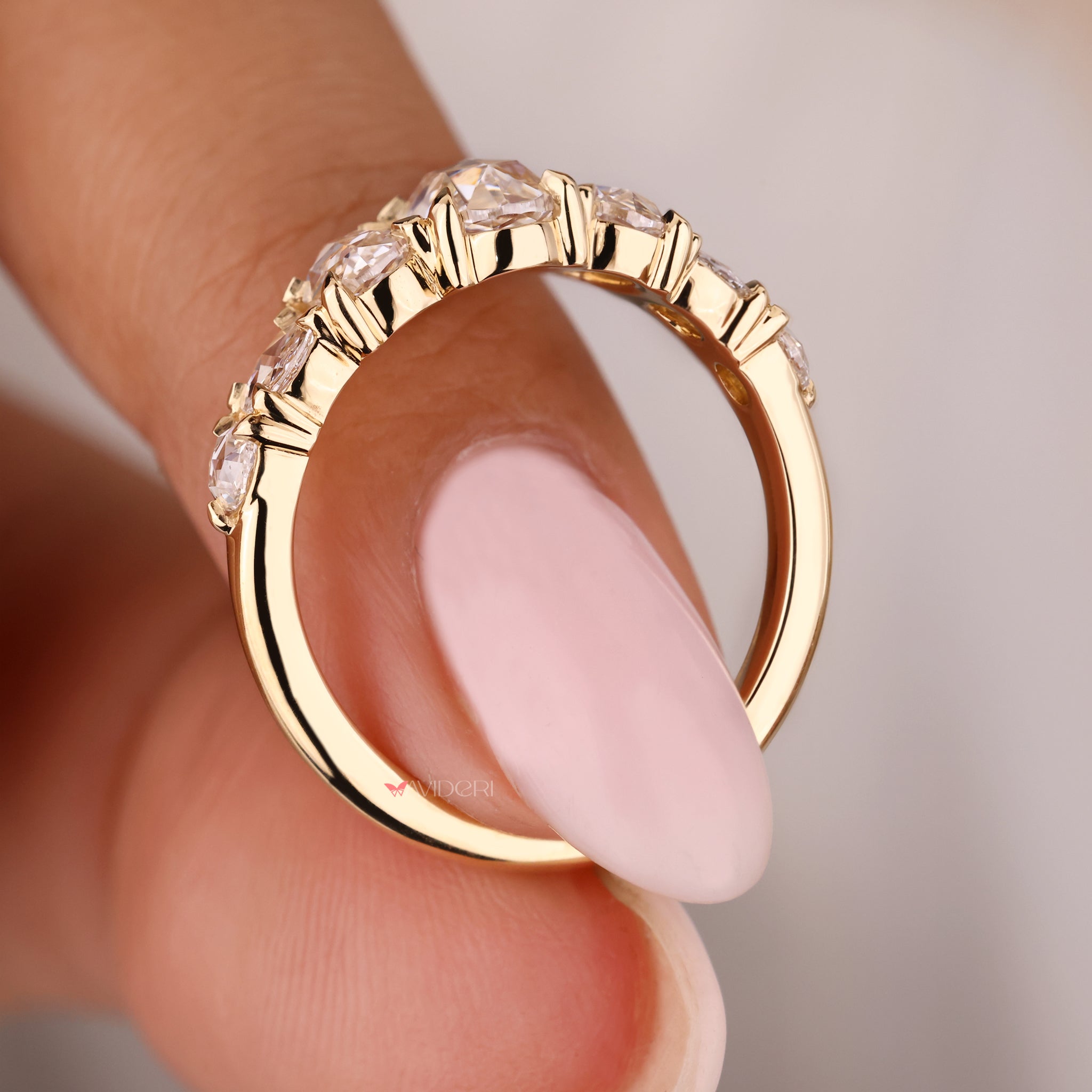 Yellow gold wedding band with oval diamonds set for a luxurious look.