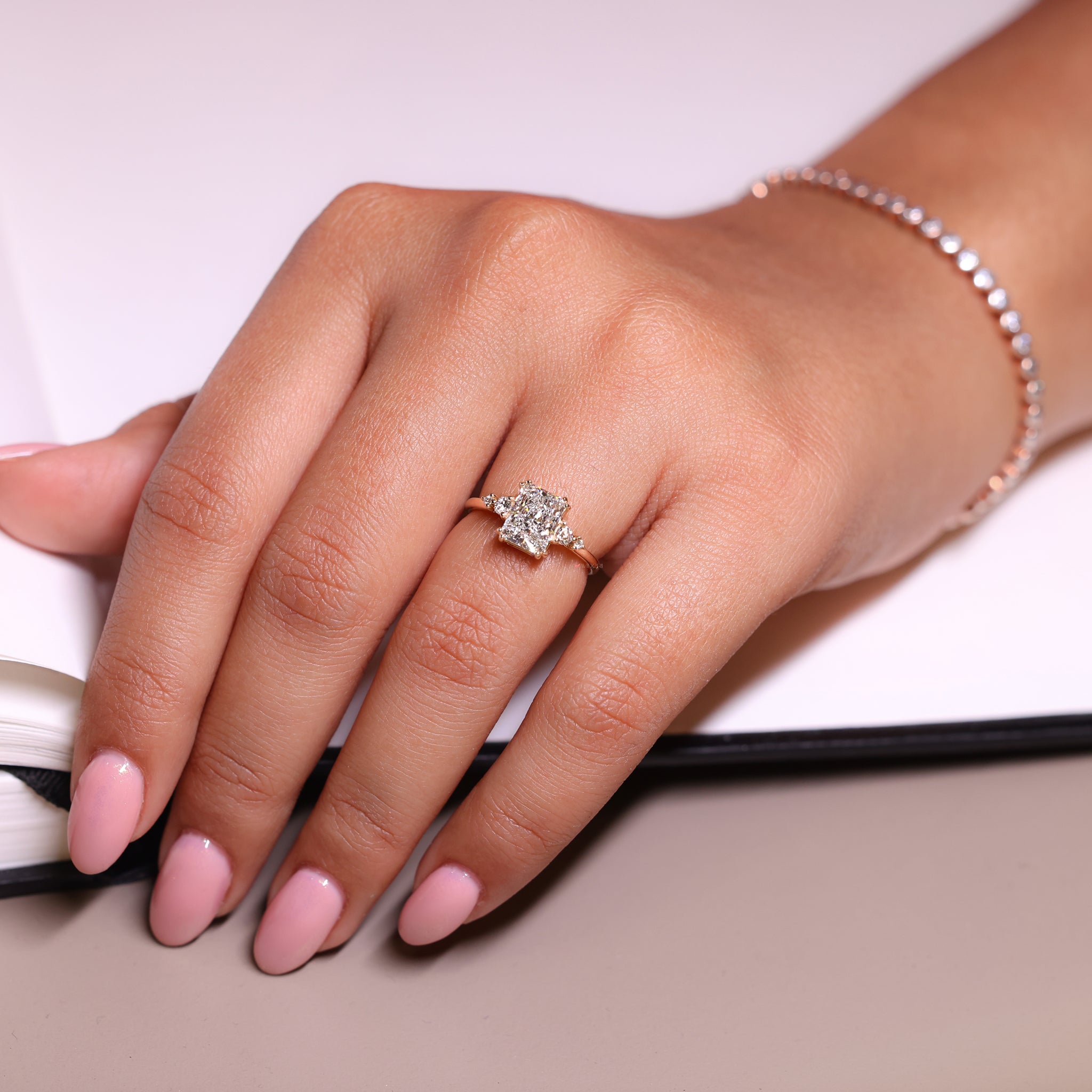Round diamond ring with radiant cut diamond for added elegance.