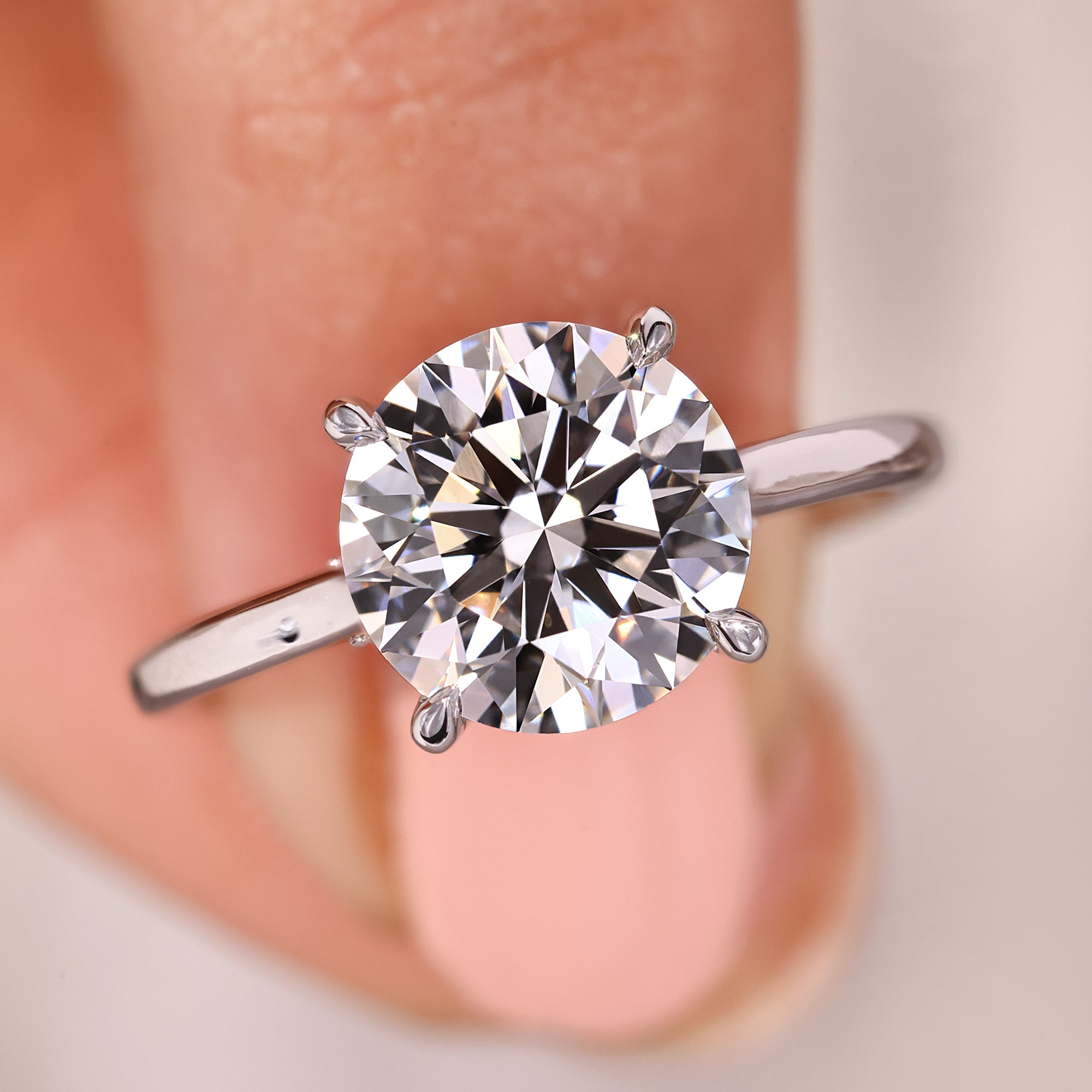 Round diamond solitaire ring with hidden halo and tapered shank