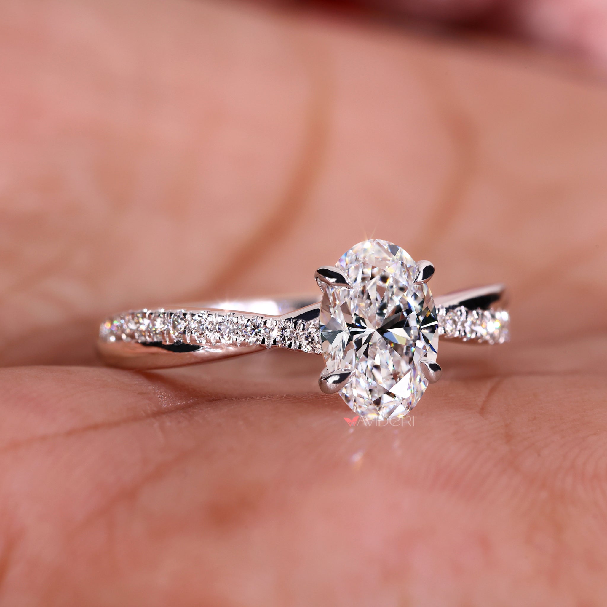 Avideri ring with a twisted ring design featuring an oval cut ring and a pave engagement ring band.