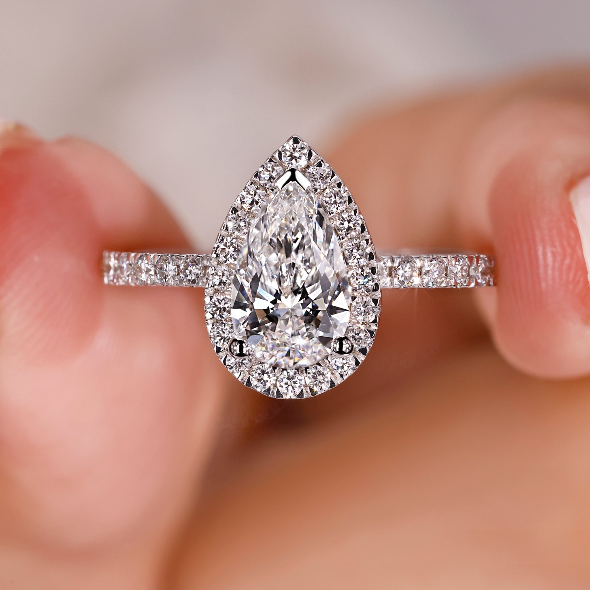 Pear shaped engagement ring with pave setting in white gold.